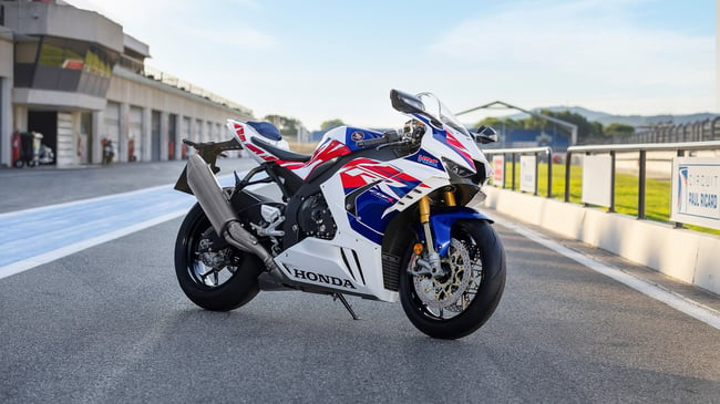 2023 Honda CBR100RR-R Fireblade is parked at a racetack, and features red, white and blue fairings. 