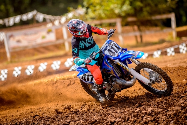 Dirt bike rider expertly controlling body positioning for optimal balance and control, demonstrating effective dirt biking technique
