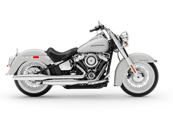 Elegant white Harley-Davidson Softail Deluxe in a side view, showcasing its classic design and luxurious features