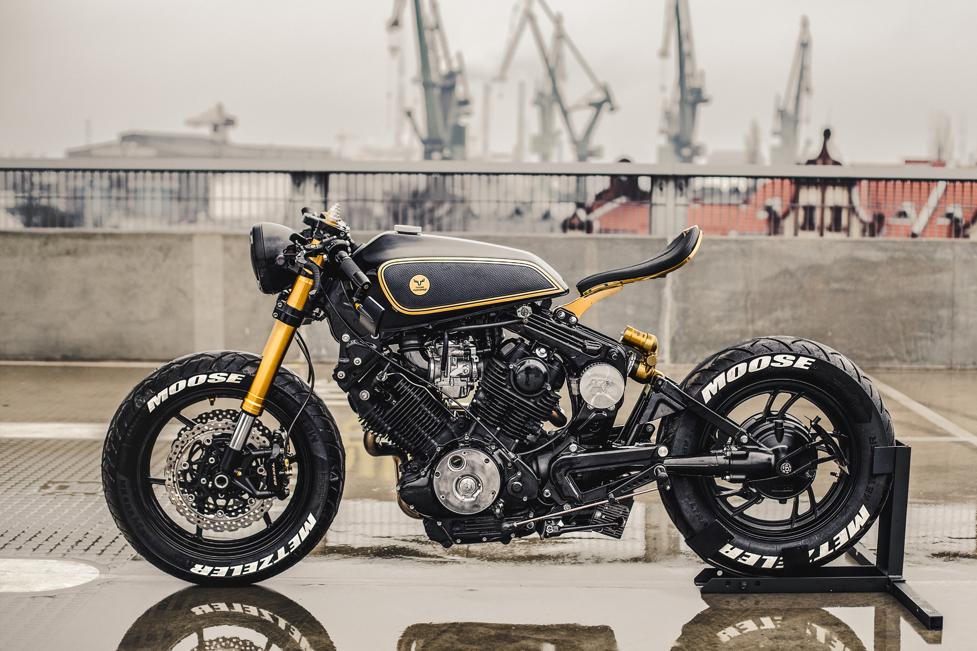 Classic Moose cafe racer bike against gritty industrial backdrop for vintage vibe