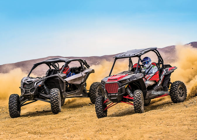 Can Am vs Polaris: A side-by-side comparison of these off-road vehicles parked on sand with a sandstorm background.