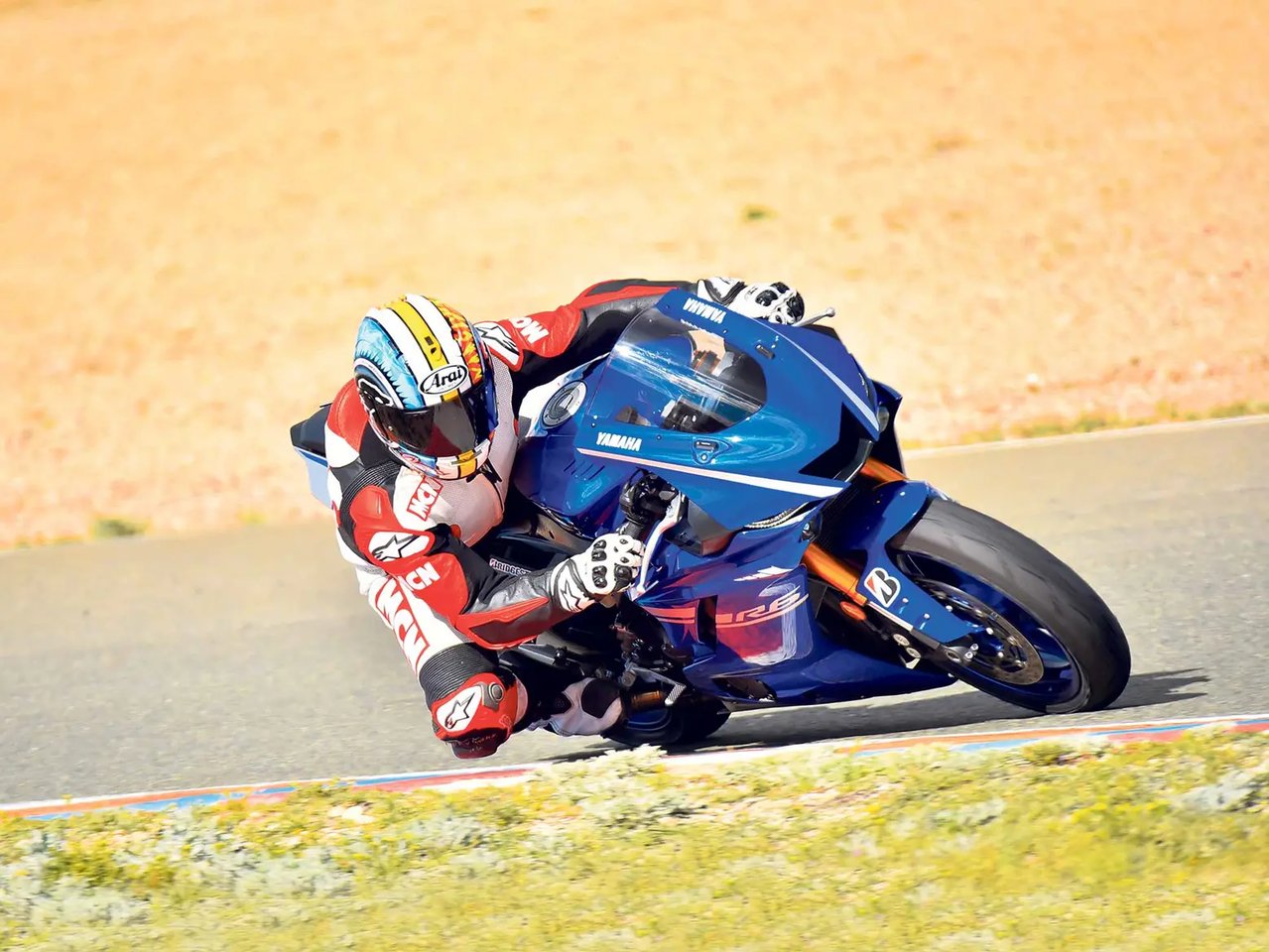 Rider in full gear expertly leaning on a high-speed street bike during a dynamic turn