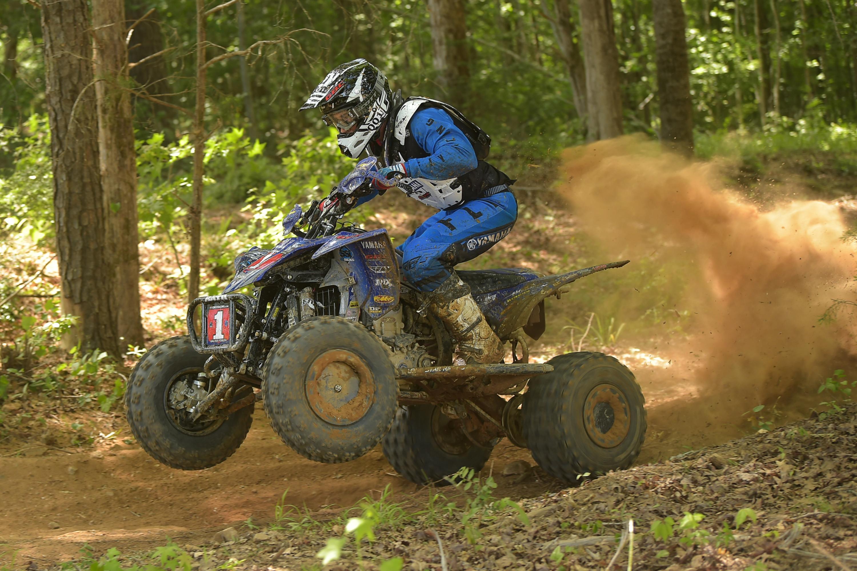 Yamaha GNCC rider wheelies on dirt trail