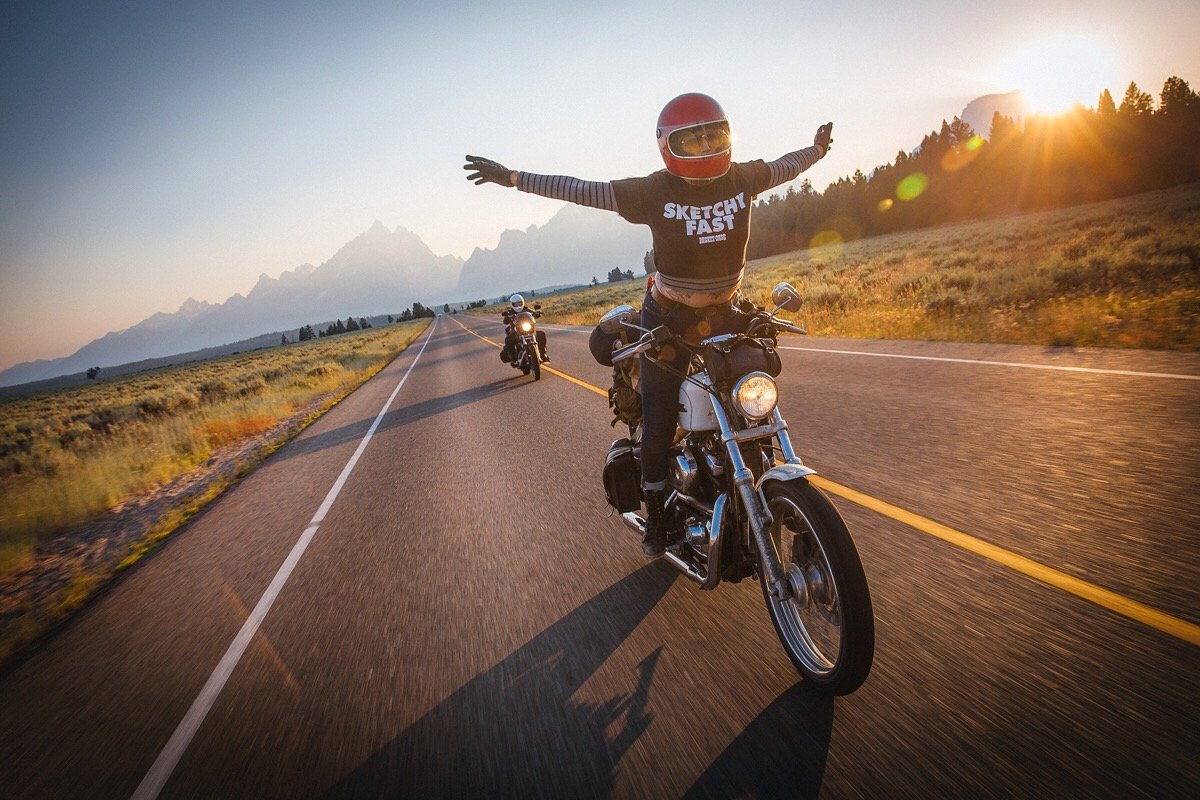 Female biker riding hands-free with arms spread wide for ultimate freedom
