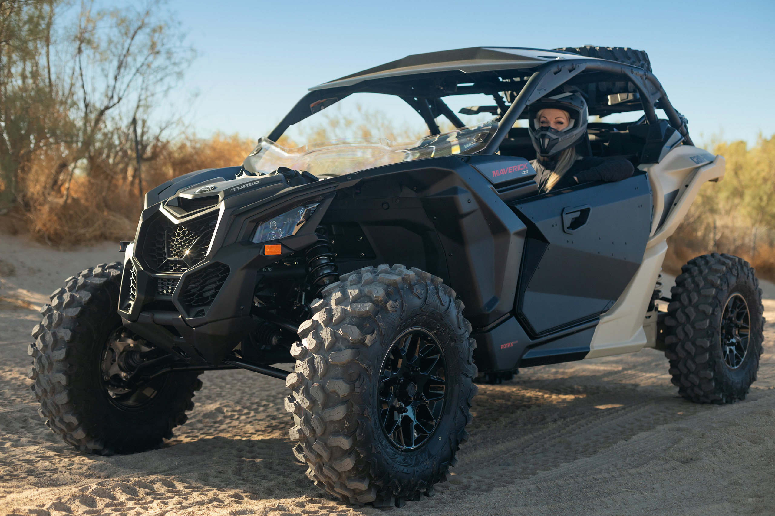 Can-Am Maverick UTV parked on sandy trail, showcasing passenger side drive - Off-road adventure with power and style