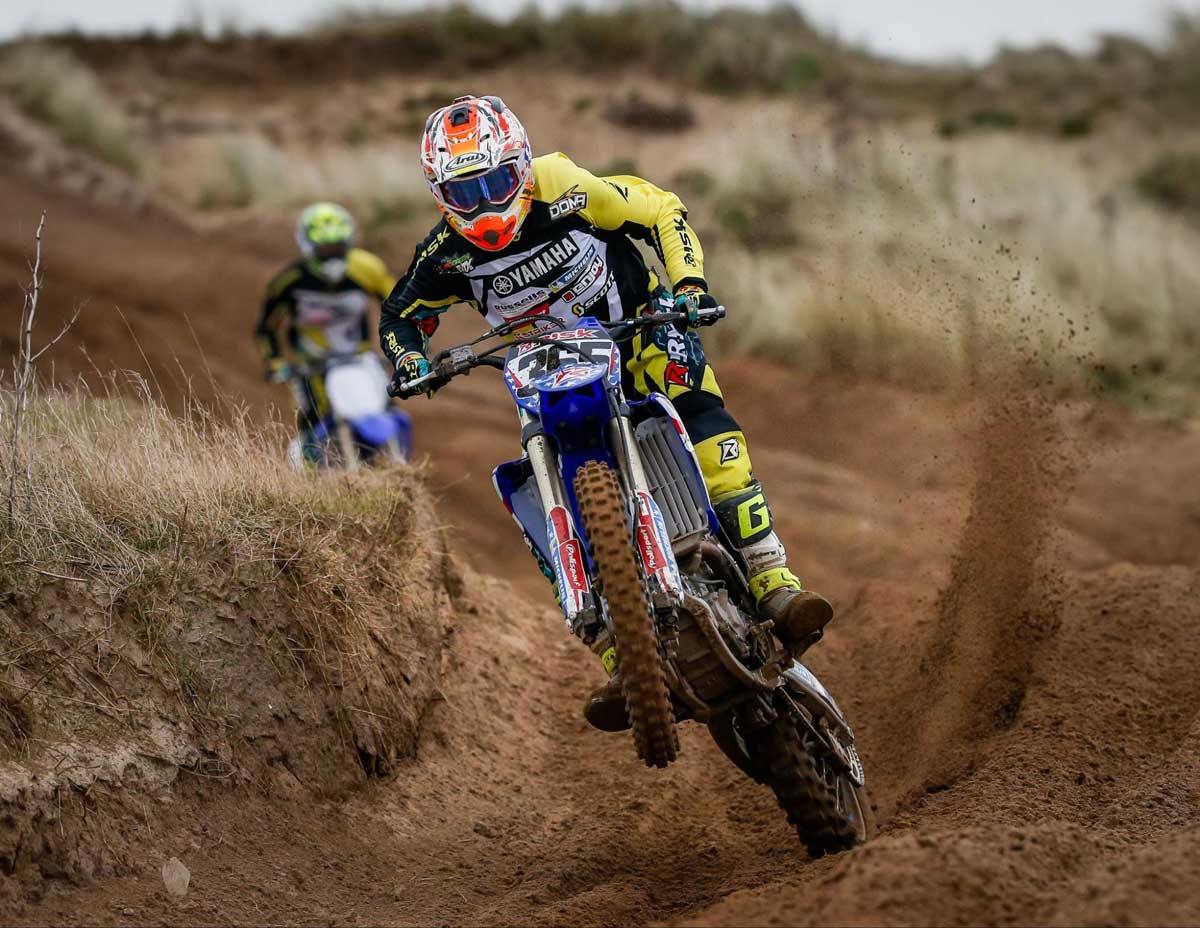Motocross rider popping wheelie after exiting turn with style