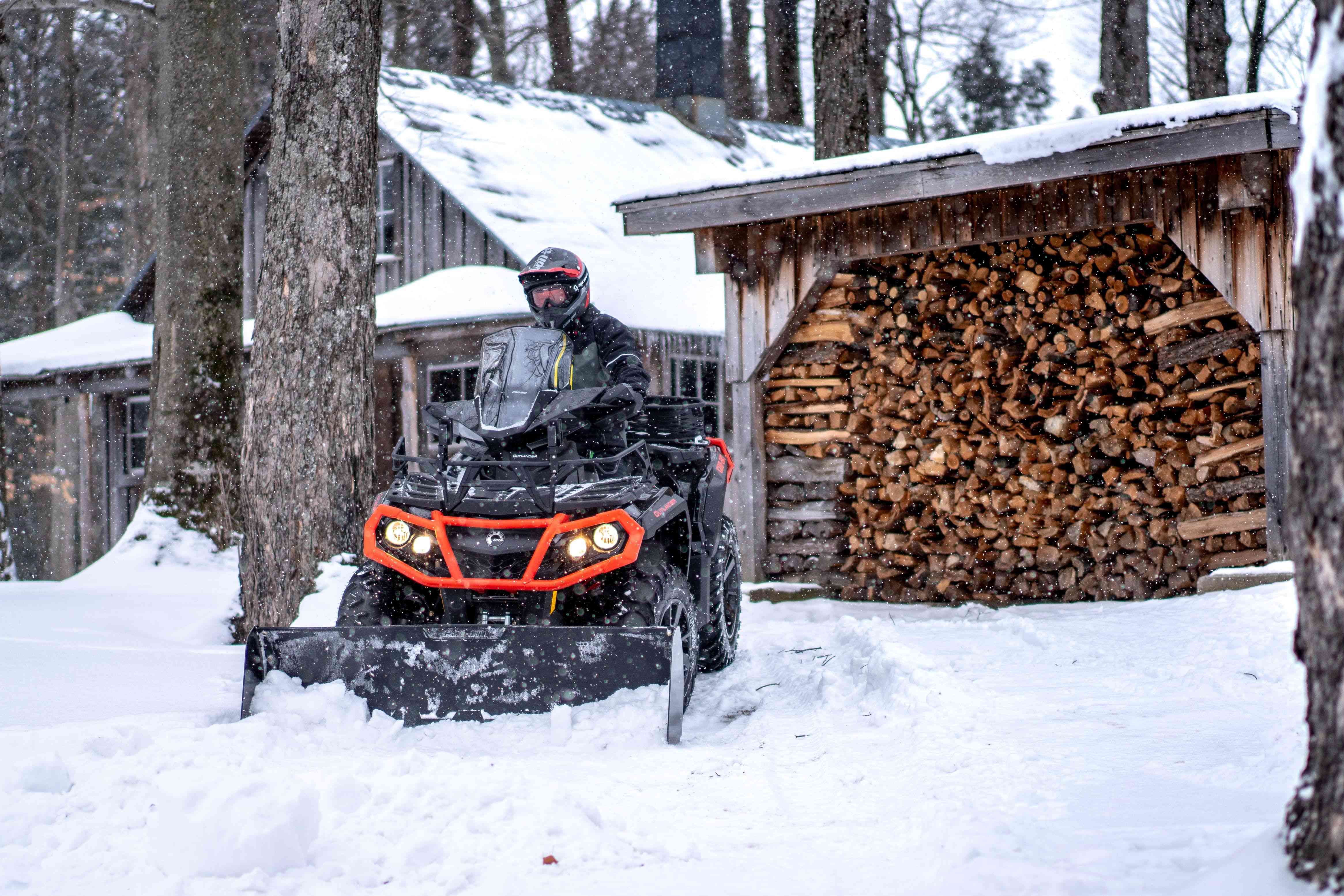 ATV rider enjoying winter adventure near cozy cabin